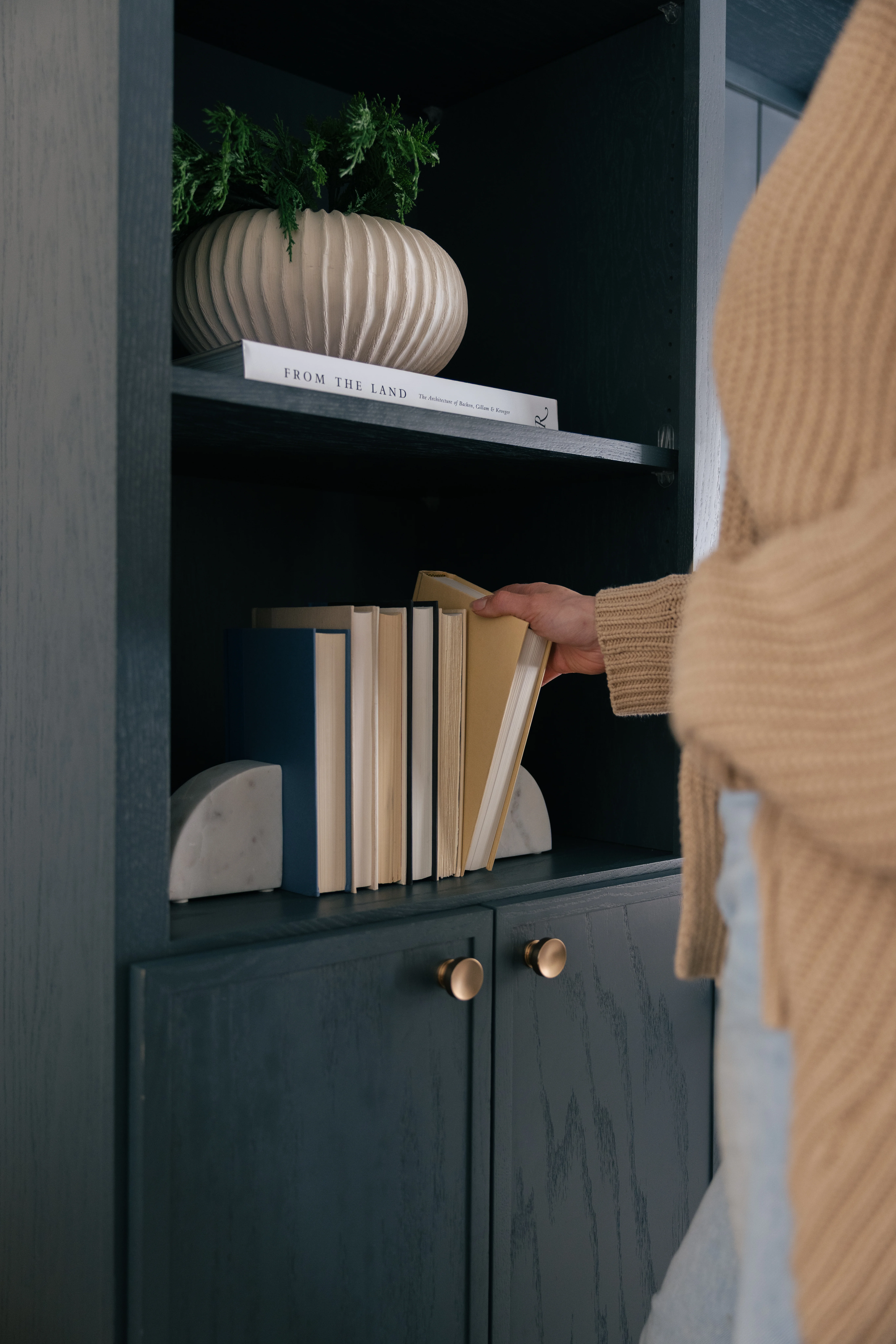 Library decor detail with curated books, art objects, and styled shelving vignette